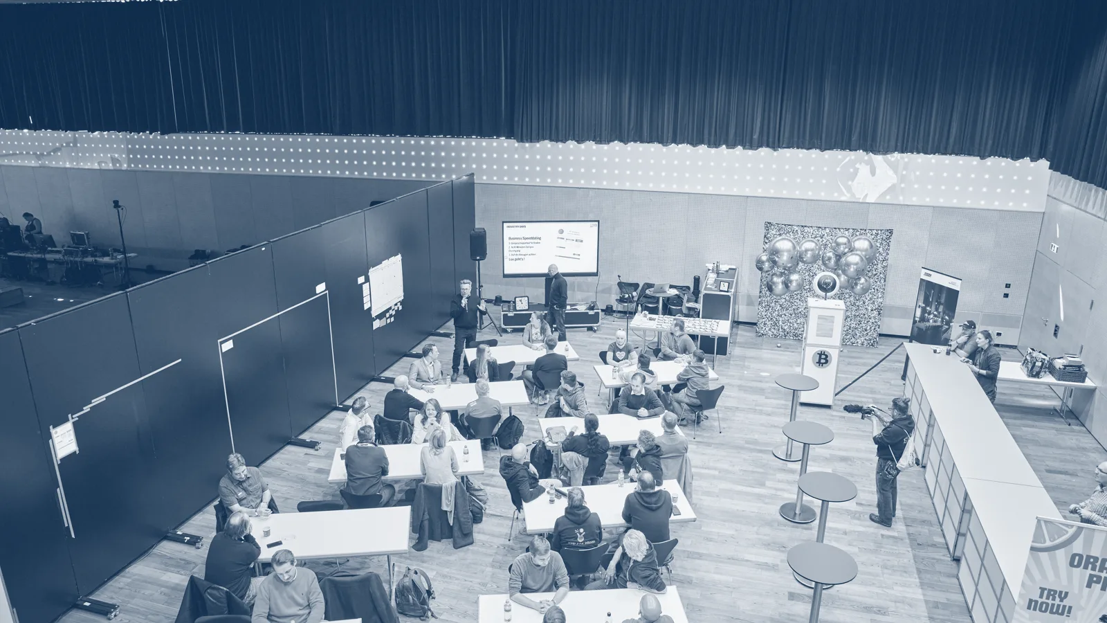 Innovation Bootcamp auf der Swiss Bitcoin Conference: Arbeitsgruppen an Tischen im Saal